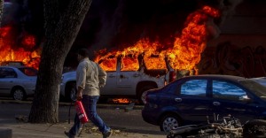 12fev2014---pessoa-carrega-extintor-de-incendio-proximo-a-veiculo-incendiado-nesta-quarta-feira-12-durante-protesto-convocado-pela-oposicao-em-caracas-na-venezuela-um-militante-governista-morreu-1392243689960_956x500
