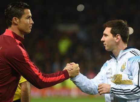 Argentina striker Lionel Messi (R) shakes hands with Portugal's striker Cristiano Ronaldo (L) ahead of kick off of the international friendly football match between the Argentina and Portugal at Old Trafford in Manchester on November 18, 2014. AFP PHOTO / PAUL ELLIS